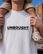Person wearing a white t-shirt with 'UNBOUGHT' text, holding a child.